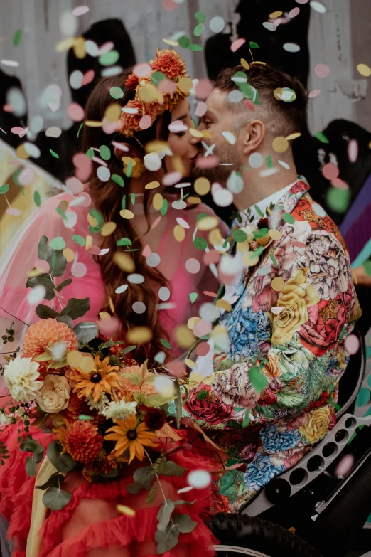 a couple sitting on a chair with confetti in front of them