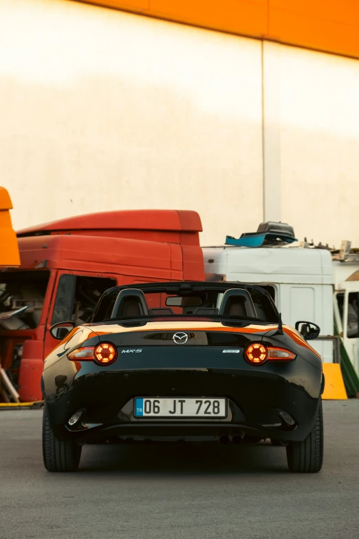 the rear end of a sports car driving down a road