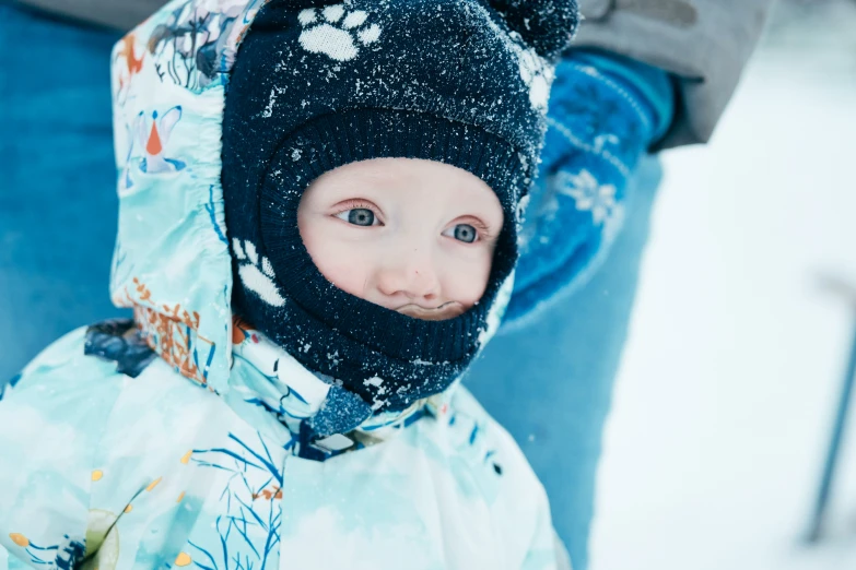 small child with a hat and coat in the snow