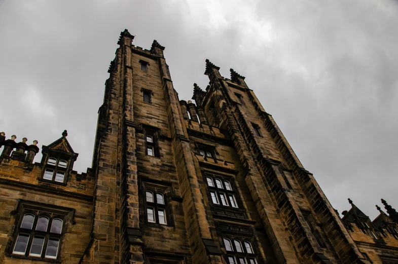 an old building with many windows against a cloudy sky