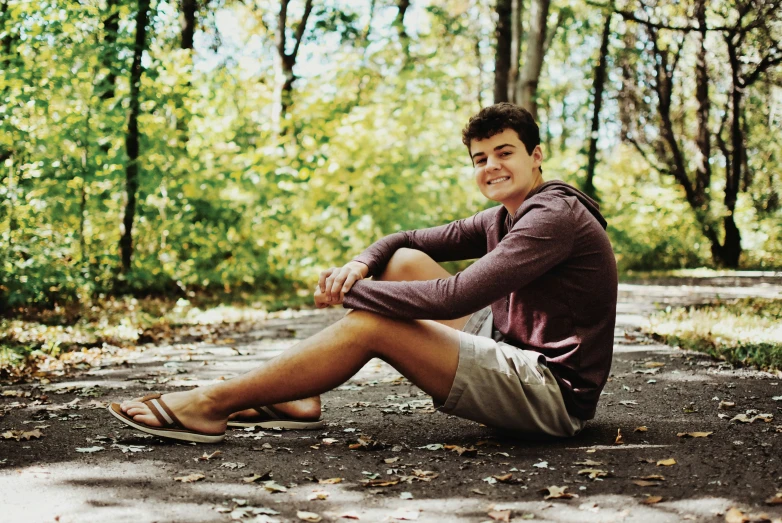 a man sitting in the middle of a road with his legs crossed