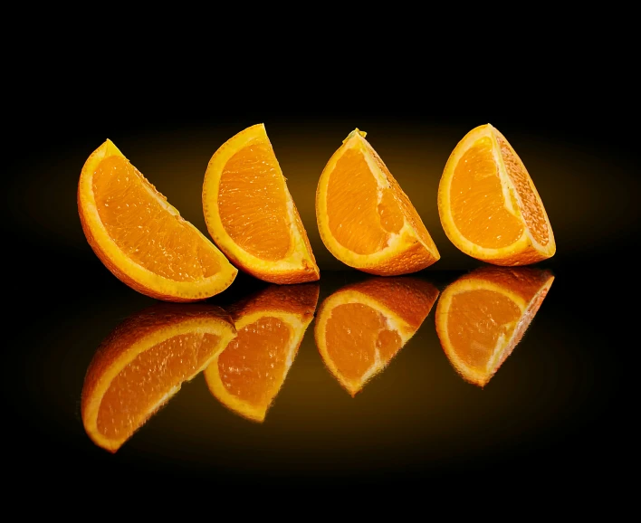 five oranges lined up on a reflective surface