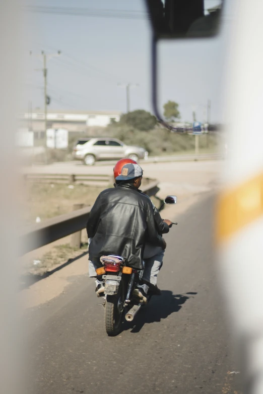 a person wearing a red helmet is on a motorcycle