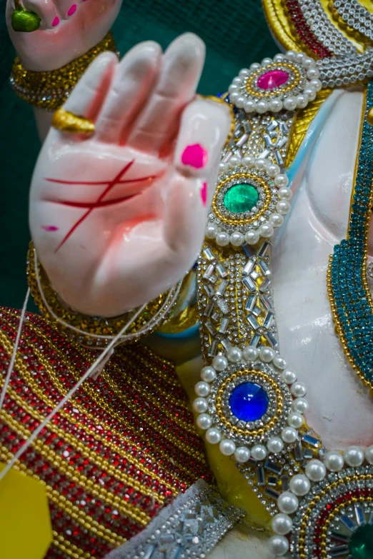 a large statue is adorned with jewels and pearls