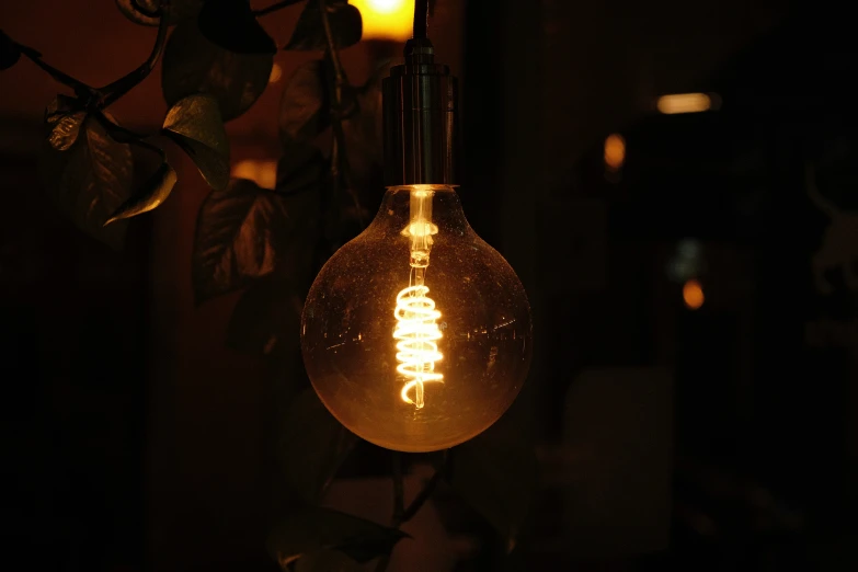 an antique light bulb hanging from a wire on the ceiling