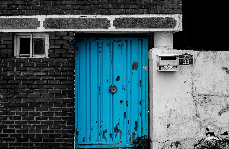 a blue door and a brick wall in a black and white po