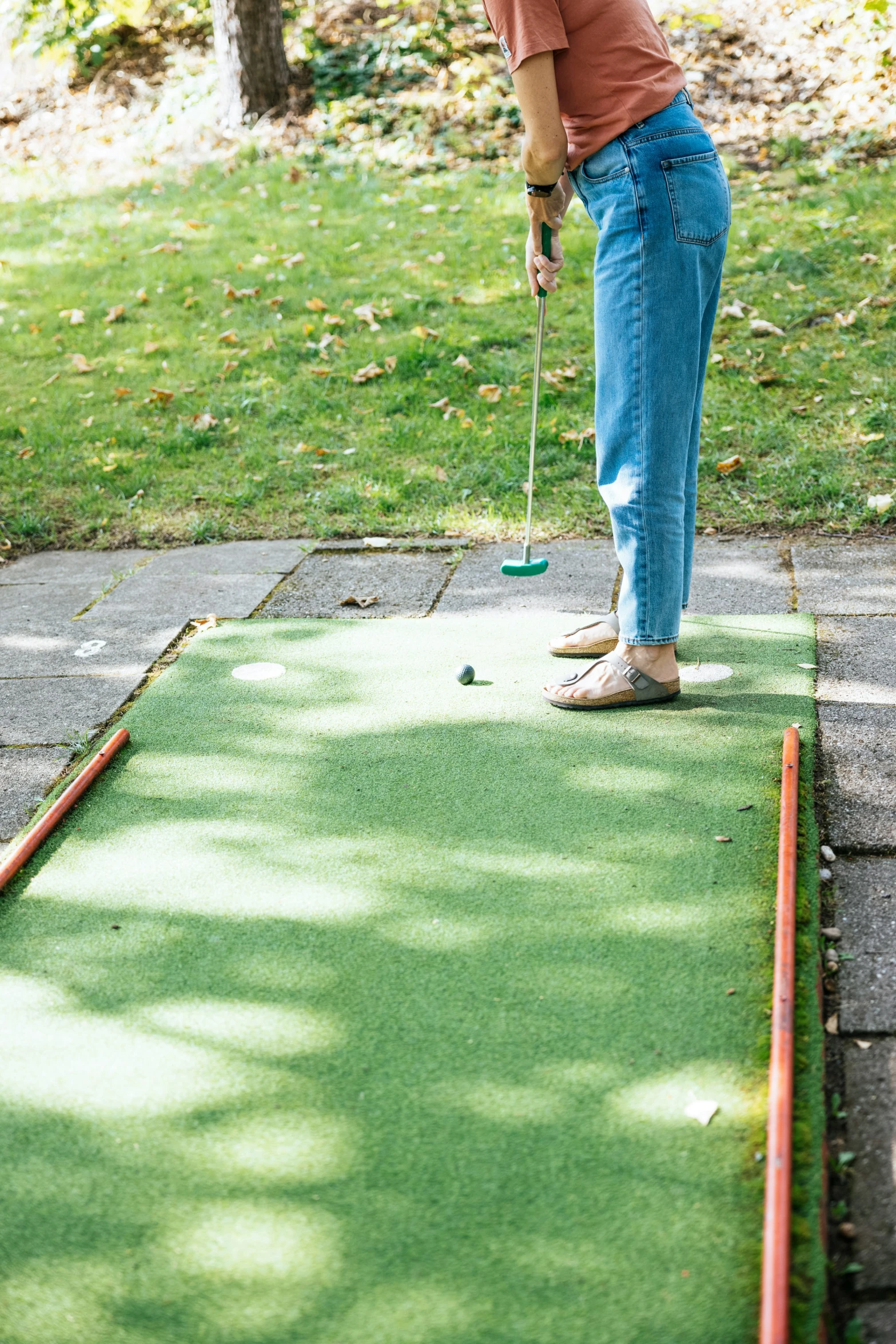 a person in jeans on a putting green