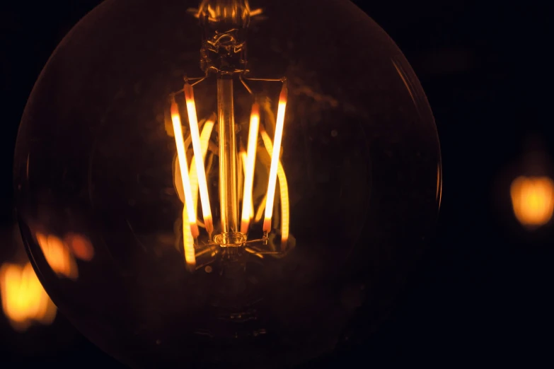 a lighted light bulb against a black background