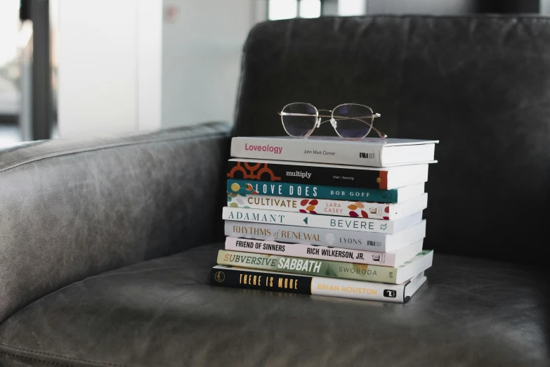 a stack of books sitting on top of a couch