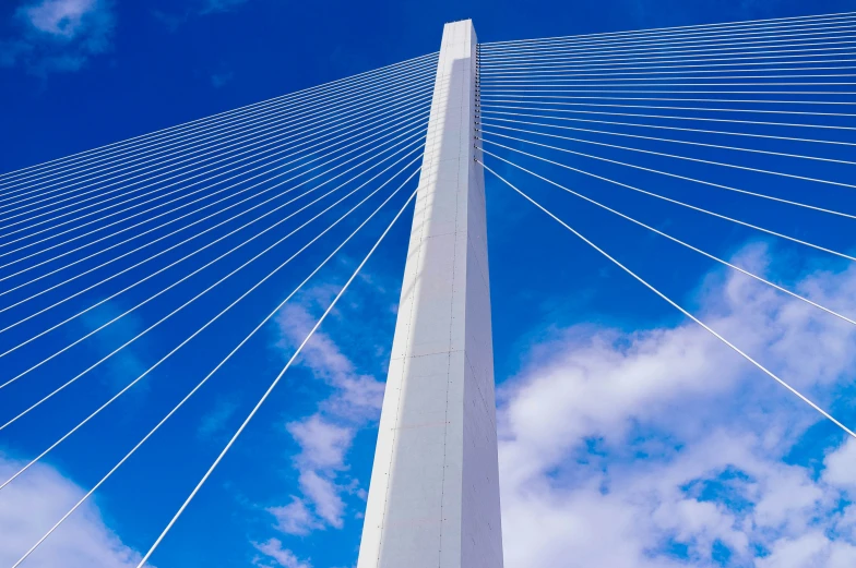 a tall white pole with some wires crossing the top