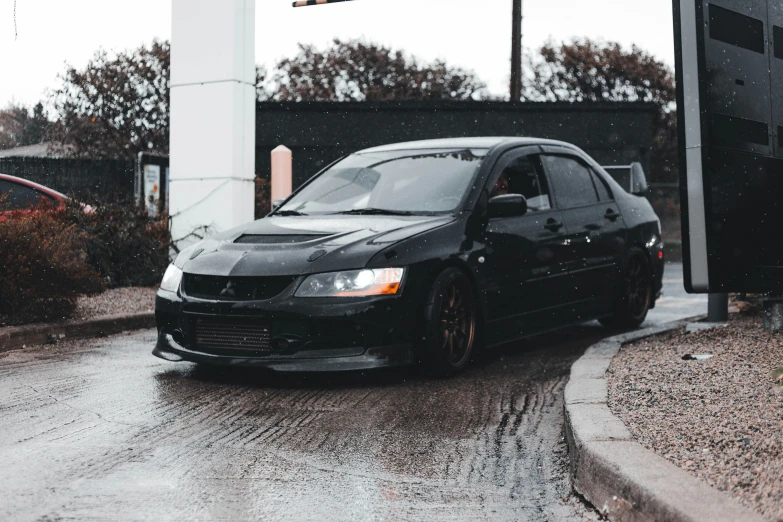 a black car parked on a wet road