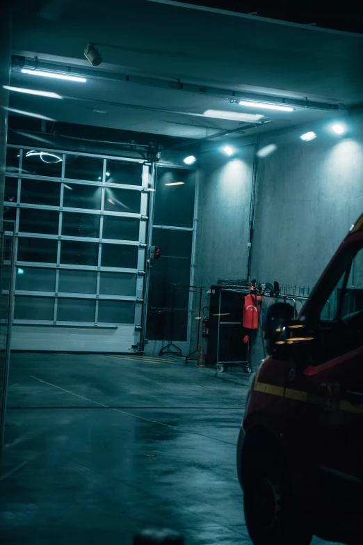 a fire engine parked next to two vehicles inside of a building