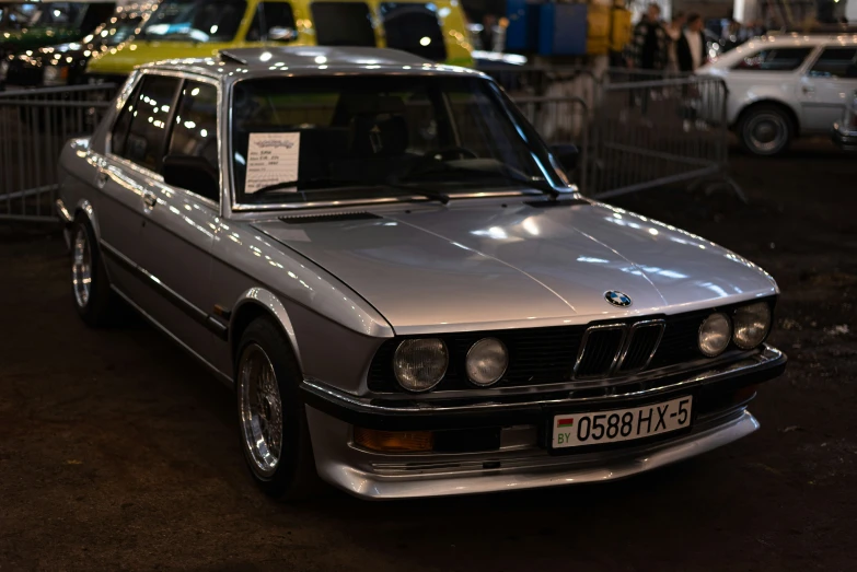 silver bmw in front of a crowd of parked cars