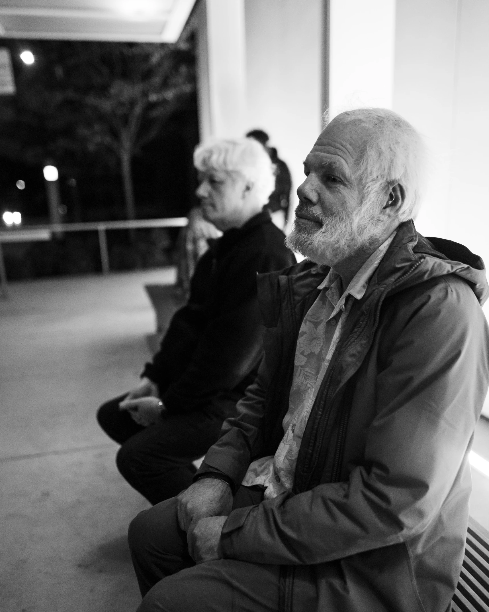 two older men are sitting side by side on a bench