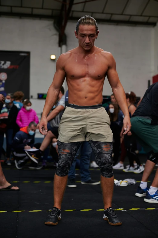 a shirtless male in shorts walking on a runway