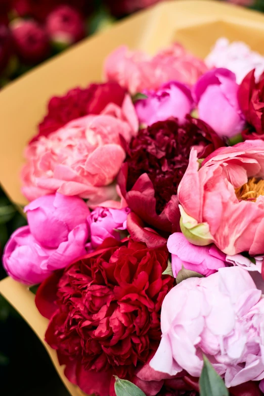 colorful flowers sit in a yellow bowl and are in a display