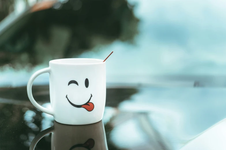 a white coffee cup has a painted face