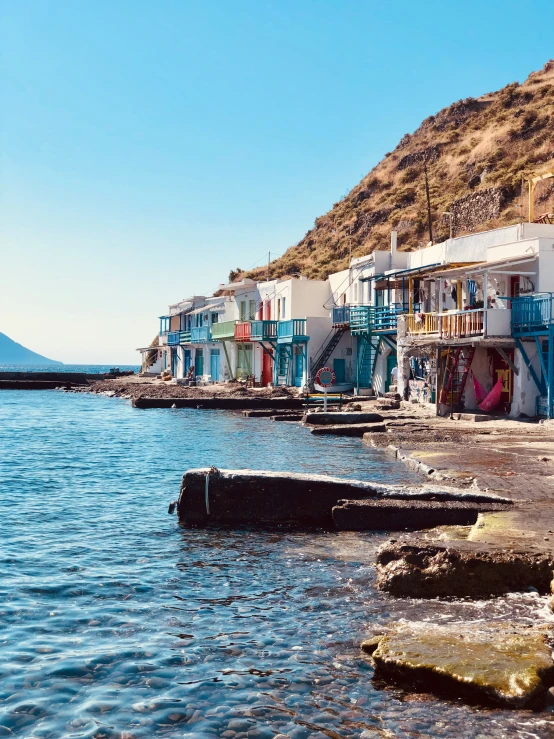 many colorful buildings next to the water on a sunny day