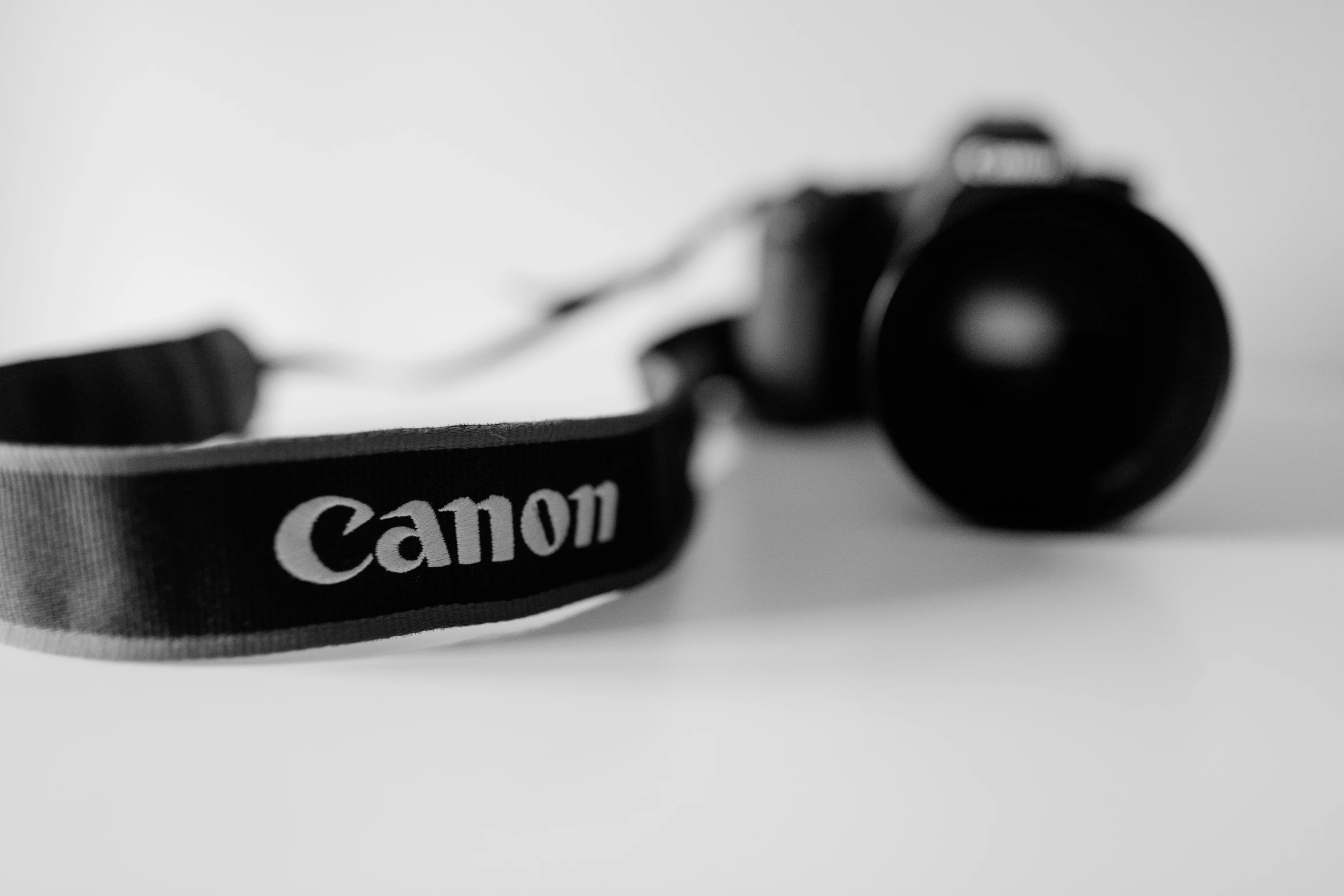camera strap with canon logo on it sitting on the table