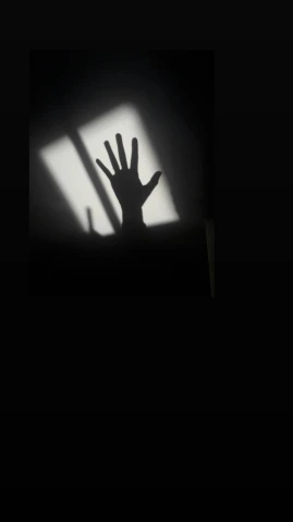 the shadow of an outstretched hand is seen on a wall