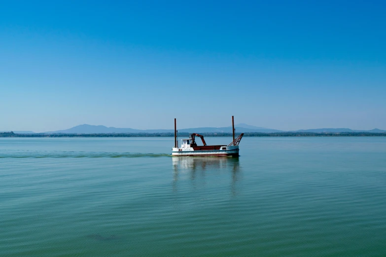 a boat on the water with mountains in the background