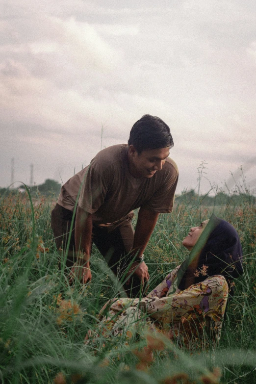 two men are in the middle of a grassy area