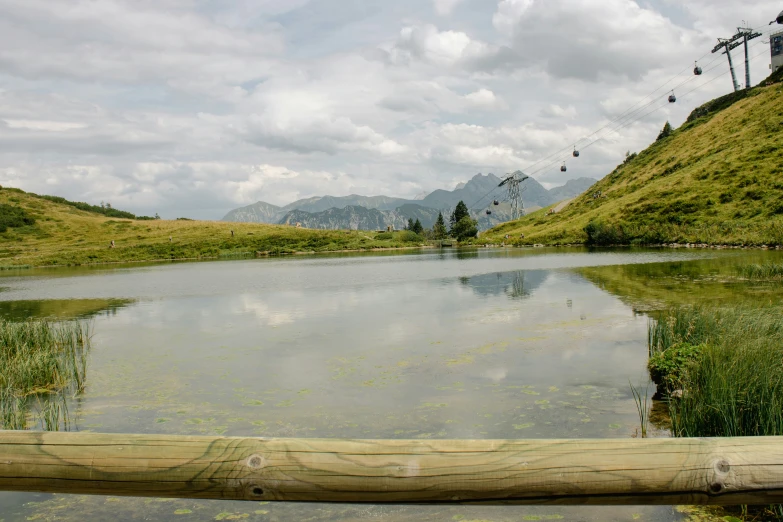 a lake in the middle of mountains under a sky filled with clouds