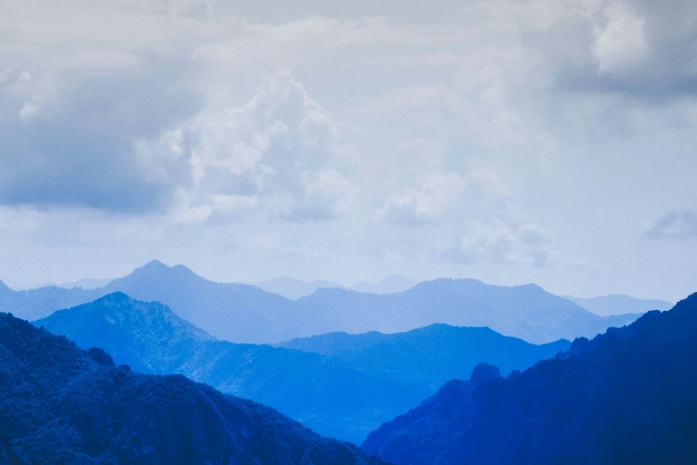 a scenic view of a mountain range under a cloudy sky