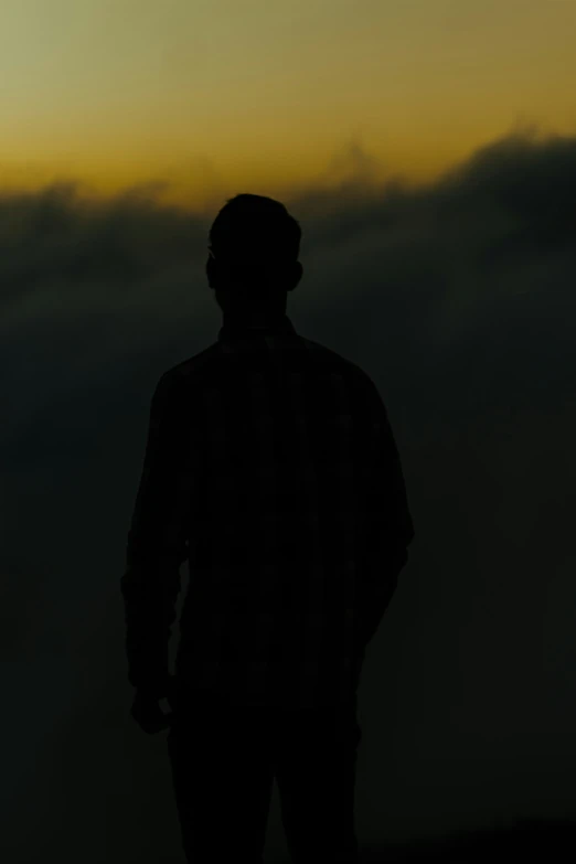 the man stands on top of a mountain against a backdrop of smoke