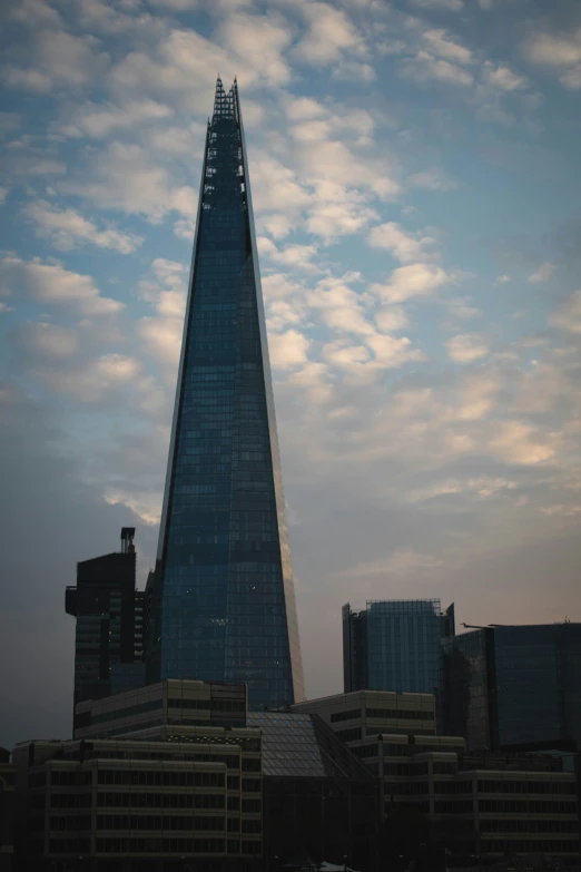 the building is very tall with the surrounding clouds