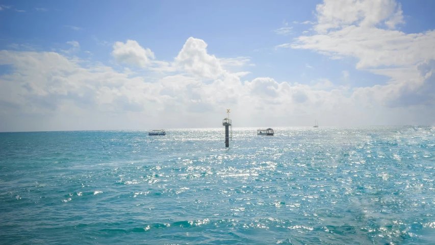 boats are anchored on calm waters as the sun rises