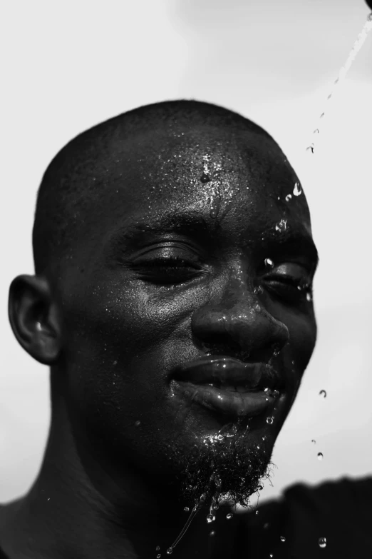 a man that is smiling under a shower