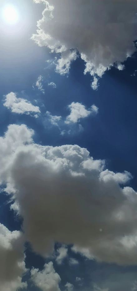 an airplane flying through a cloudy blue sky