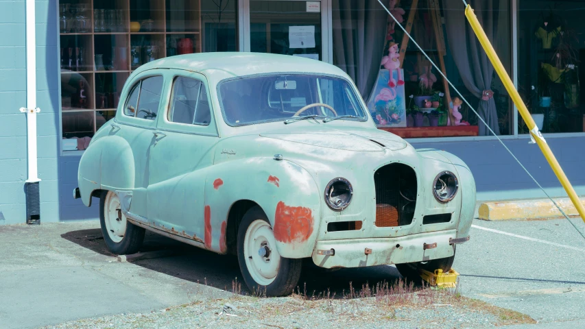 an old car is shown parked on the pavement