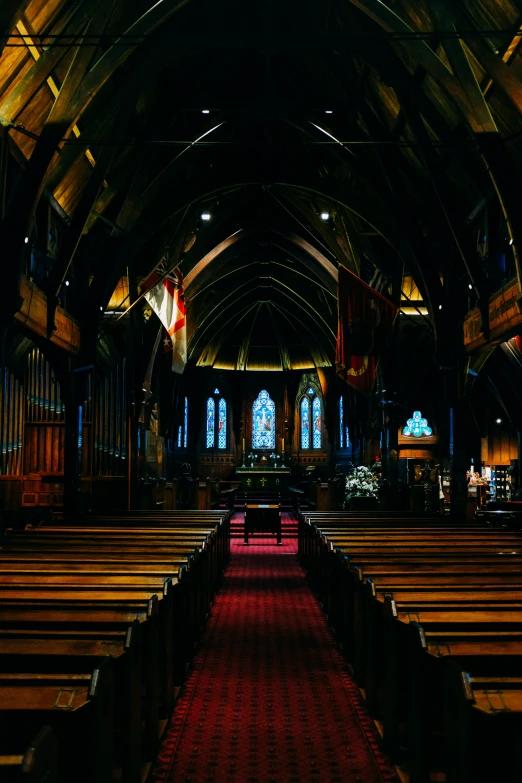 the interior of an old, wooden church with rows of pews and red carpet