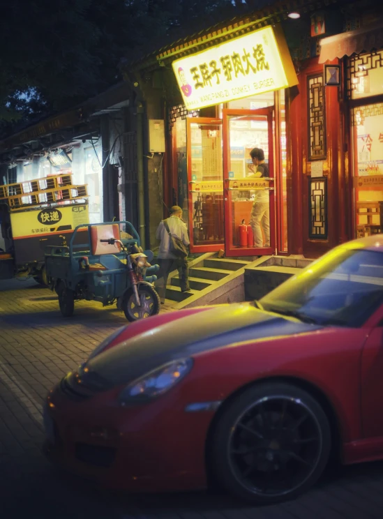 a small red sports car parked in front of a building