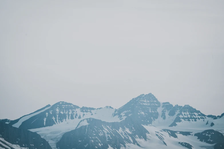 a snow covered mountain on a cloudy day