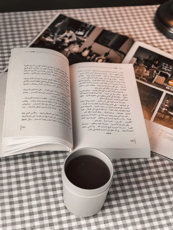 a cup of coffee next to two book pages