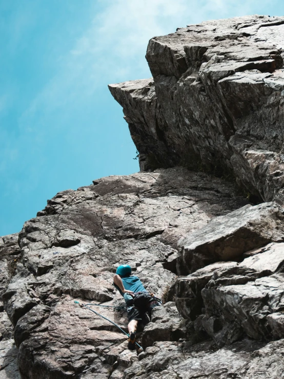 a person is climbing down the side of a mountain