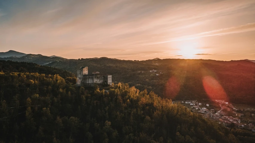 a sunset view from top of a hill over trees