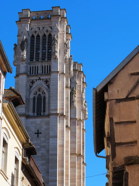 a large tower with crosses on it near a building