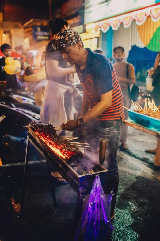 a person that is grilling on a grill with various foods