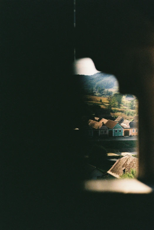 a city in the distance is seen through a window