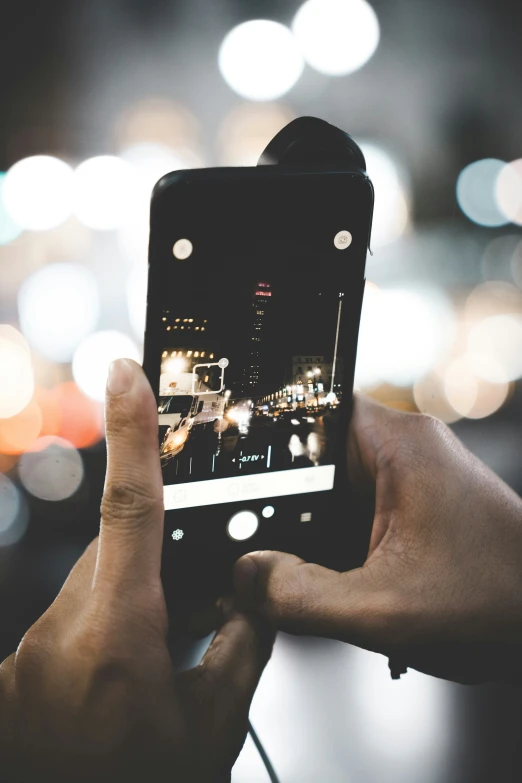 a man is taking a po with his phone at night