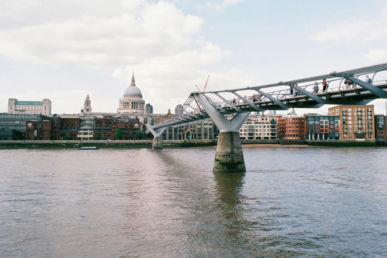 bridge crossing over water with tall buildings in the background