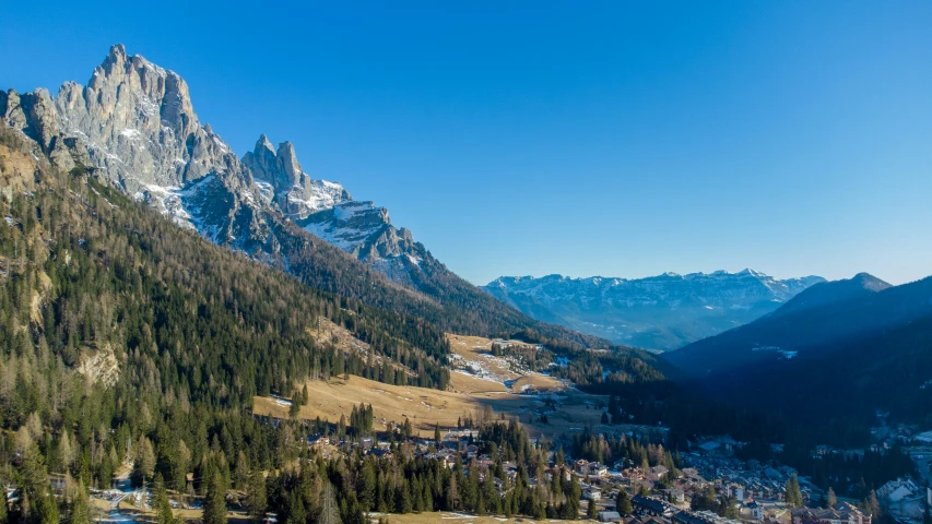 a mountain area with trees on both sides and houses