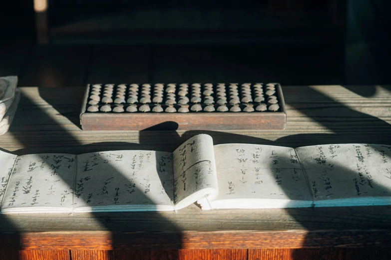 the table has a book, an ink filled cup and a bowl on it