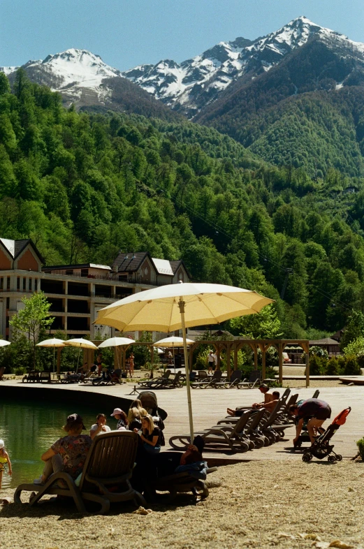 a beach area with chairs, umbrellas and some people