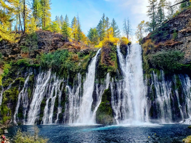 large waterfall and water fall with trees surrounding it