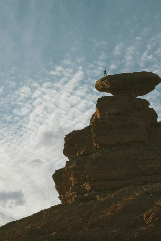 a person stands at the top of a rocky mountain